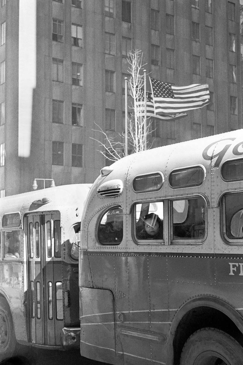 USA. NEW YORK. Lower Manhattan. Bus plus the American Flag. 1962.