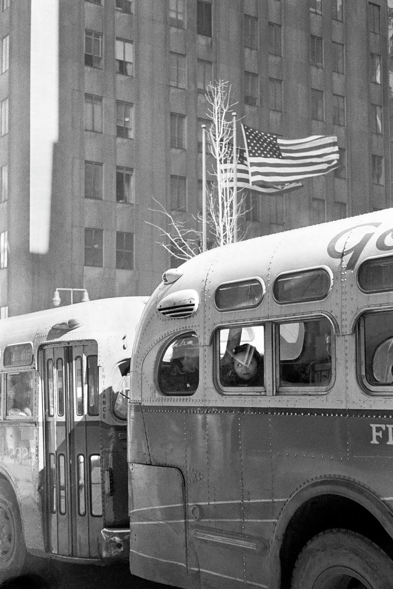 USA. NEW YORK. Lower Manhattan. Bus plus the American Flag. 1962.