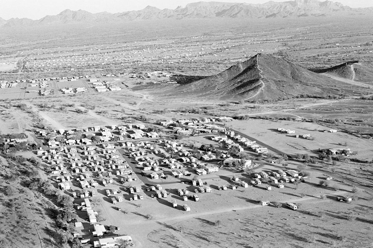 USA. ARIZONA. Quartzsite. Quartzsite is a small town, population 2000, in South-western Arizona desert.  From October through March the population increases to near the million mark.  The new visitors are called the 'Snowbirds' coming from the cold north in their RVs.  Parking in the desert costs just $50 for the whole season. This picture shows the start of the arrivals. 1997.