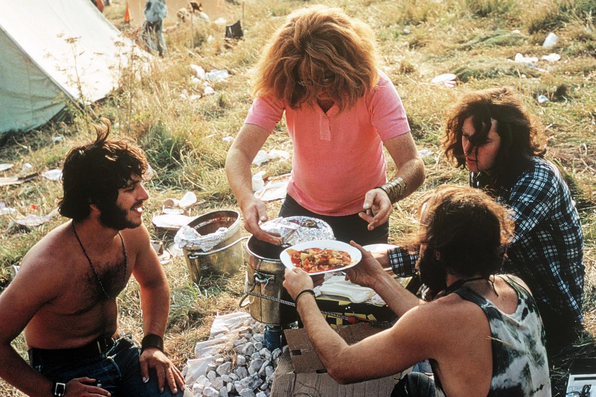 GB. ENGLAND. Isle of Wight Festival. Getting food often means a long wait, cooking your own is much better. Here a group cook soup on a minute heater made out of Coca-Cola cans. 1969.