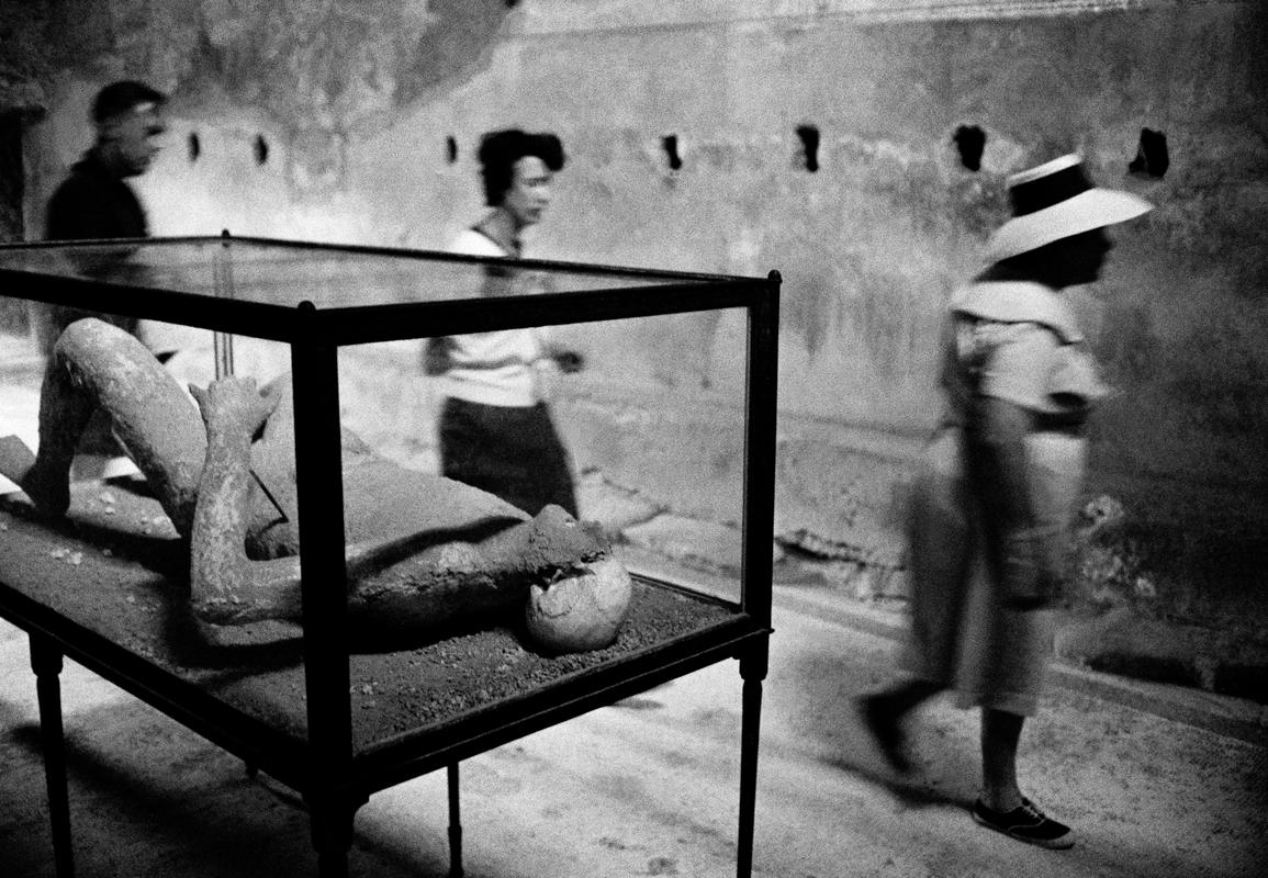 ITALY. Pompeii. Tourists walk by a petrified victim of the Vesuvius eruption in Pompeii. 1964.