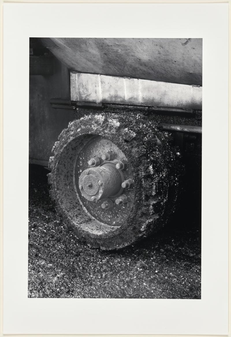 The wheel of a lorry trailer is covered in fresh tarmac as it lays new road surface on the Hindustan Tibet Road