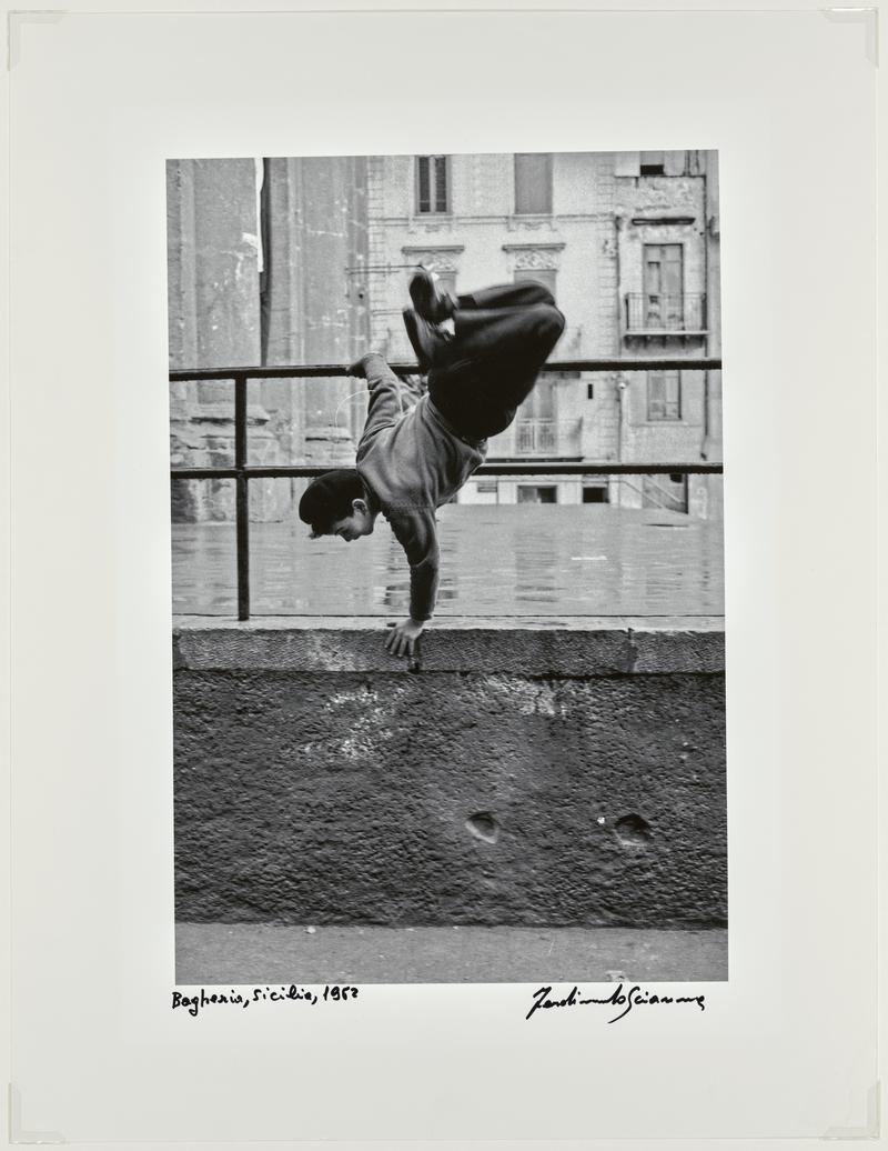 Child jumping in Piazza Adrice. Bagheroa, Sicily. Italy