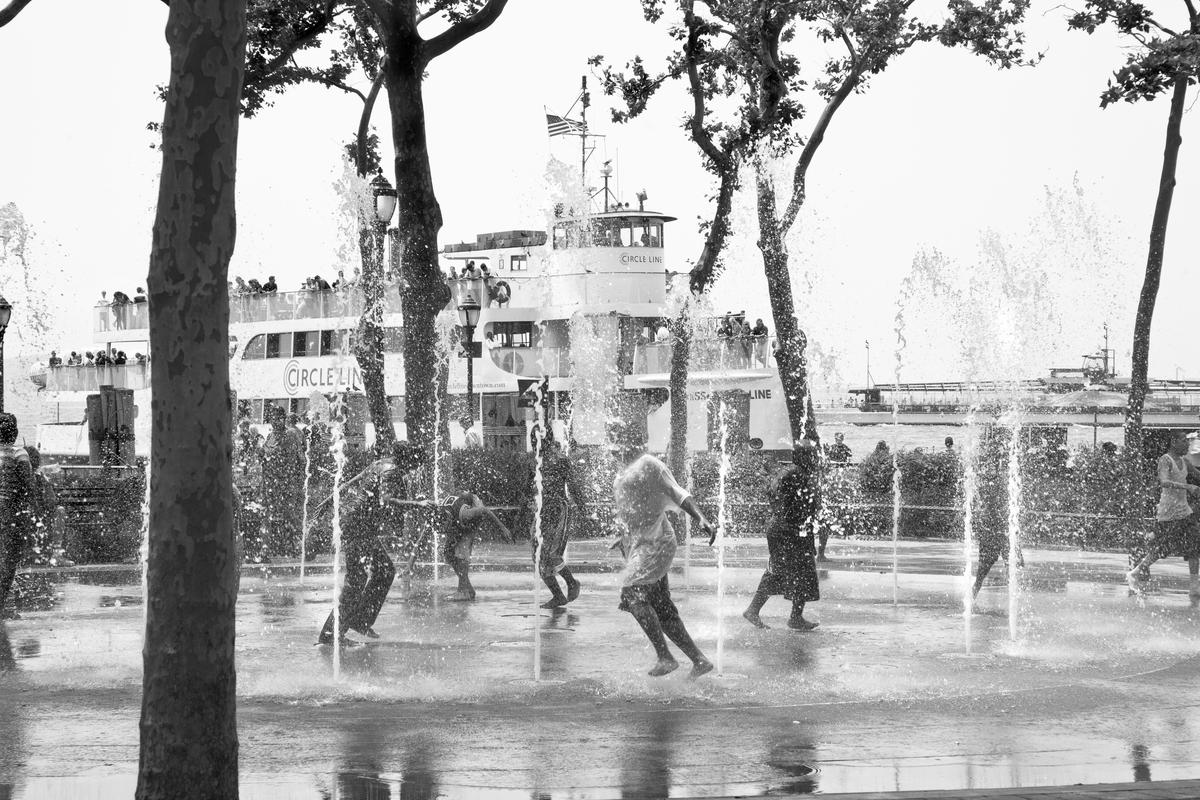 USA. NEW YORK. Playing in the water fountains in Battery Park lower Manhattan. 2007