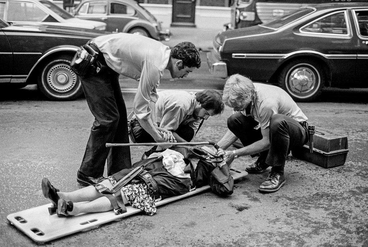 USA. NEW YORK. Street casualty. Accident or simply a fall. Ambulance personnel oversee. 1980