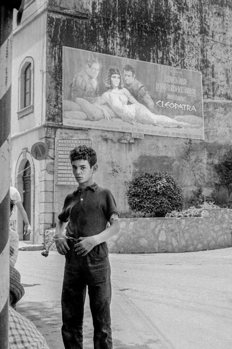 ITALY. Sicily. Taormina. Boy and flower plus cinema poster. 1964.