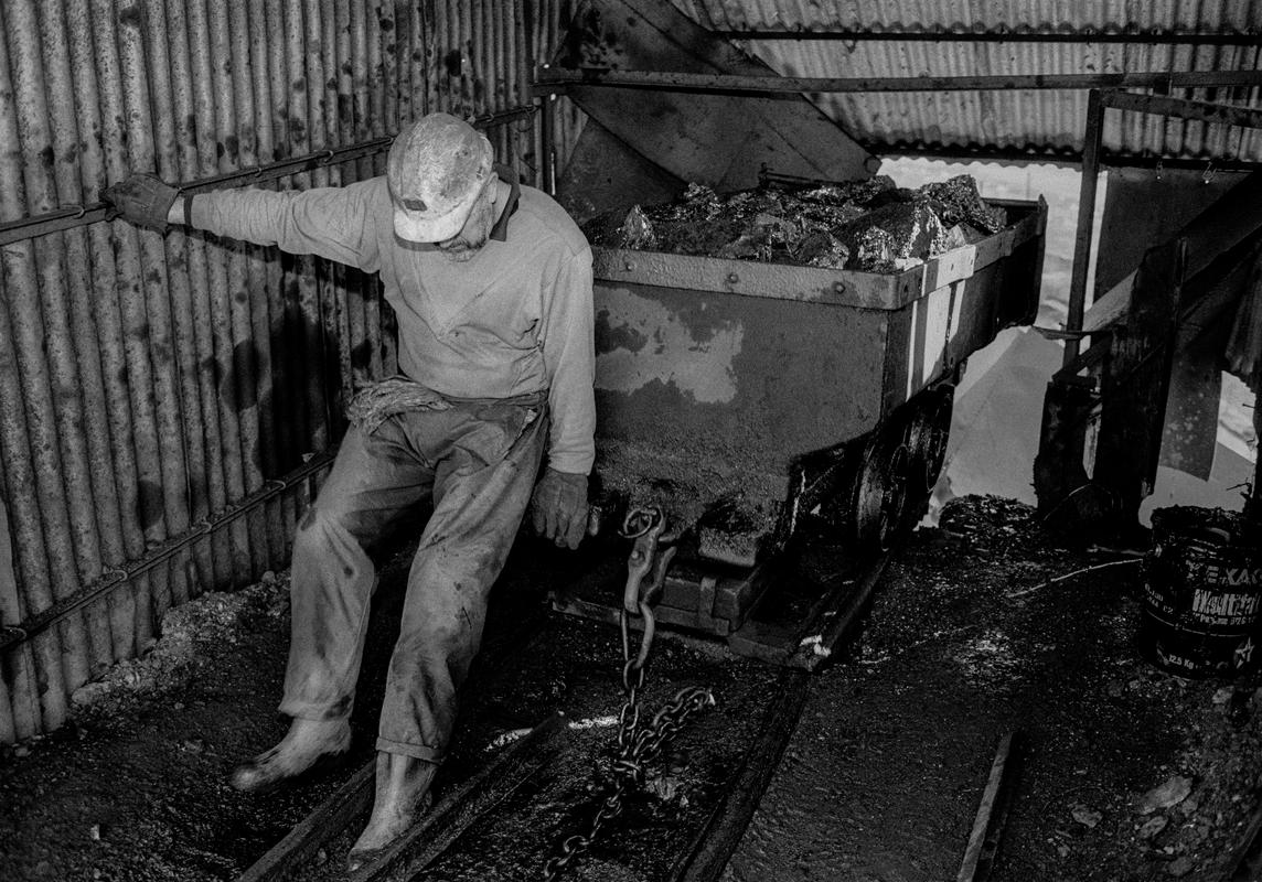 GB. WALES. Neath Valley. Black mountain coal. Miners emptying a coal cart. 1993
