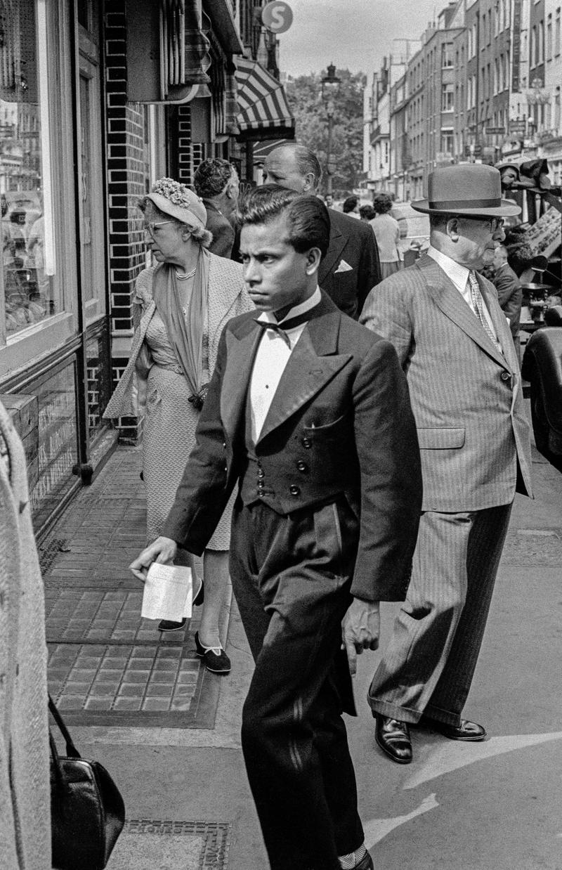 GB. ENGLAND. London. Street scene in Soho in the centre of London. A waiter from one of the many local restaurants. One of the first pictures ever taken by David Hurn, shot on a Kodak folding Retina camera (first camera). 1955.