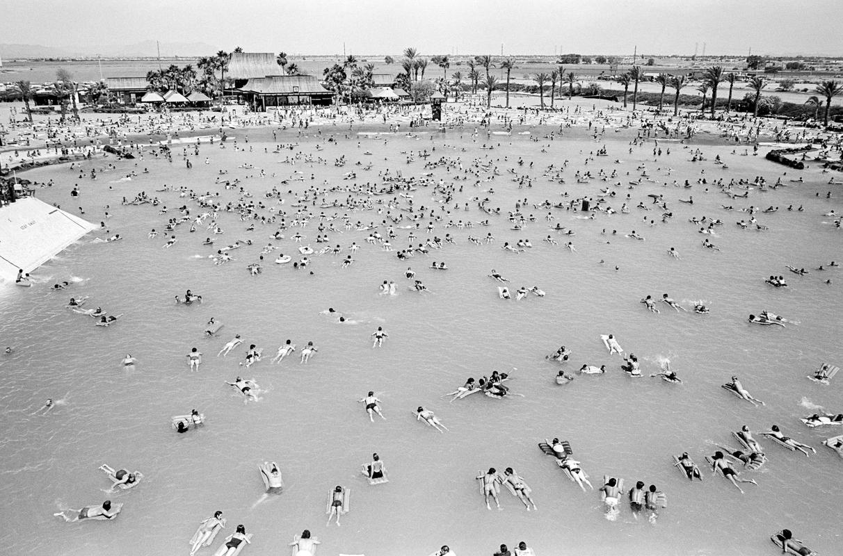 USA. ARIZONA. Big Surf in the middle of the desert.  A large freshwater lagoon where you can ride rolling breakers up to five feet high, created by a hydraulic wave maker. The waves roll onto a palm dotted, four acre, sandy beach. 1980.