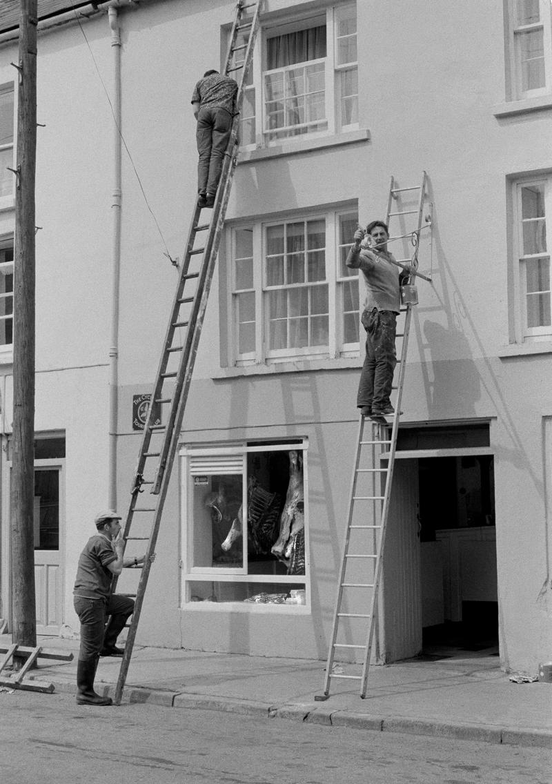 IRELAND. Killarney. Painting the butcher shop. 1984.