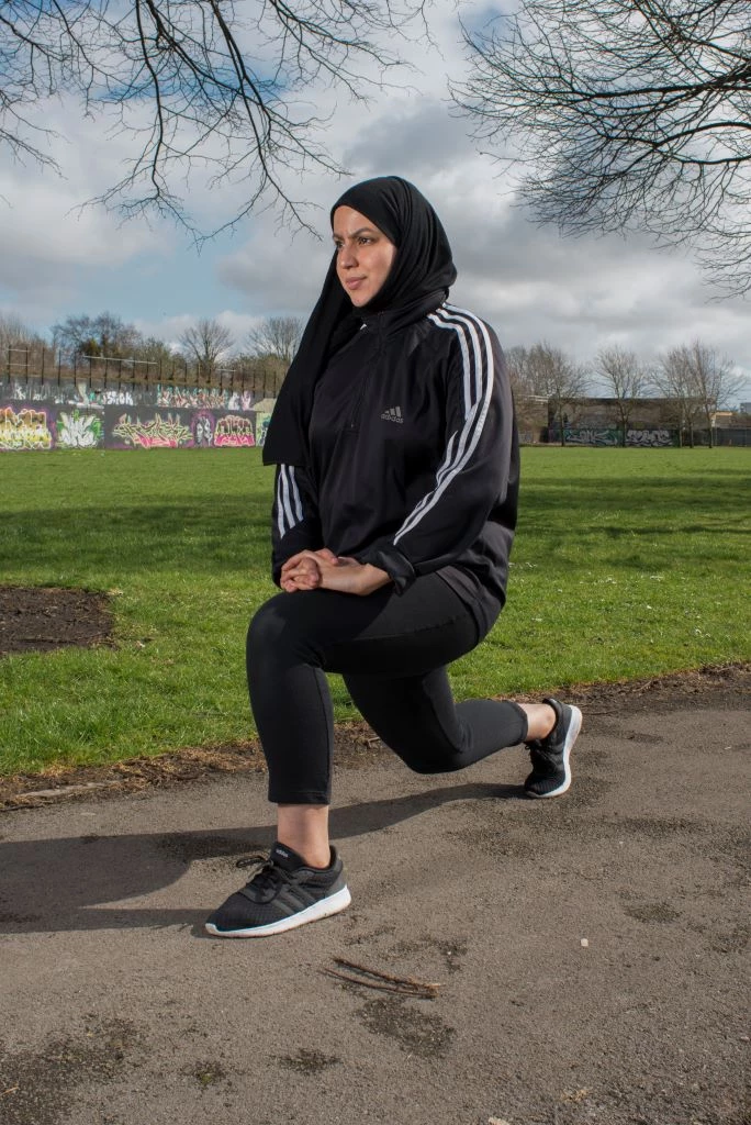 Menyw yn ei dillad ymarfer corff mewn parc